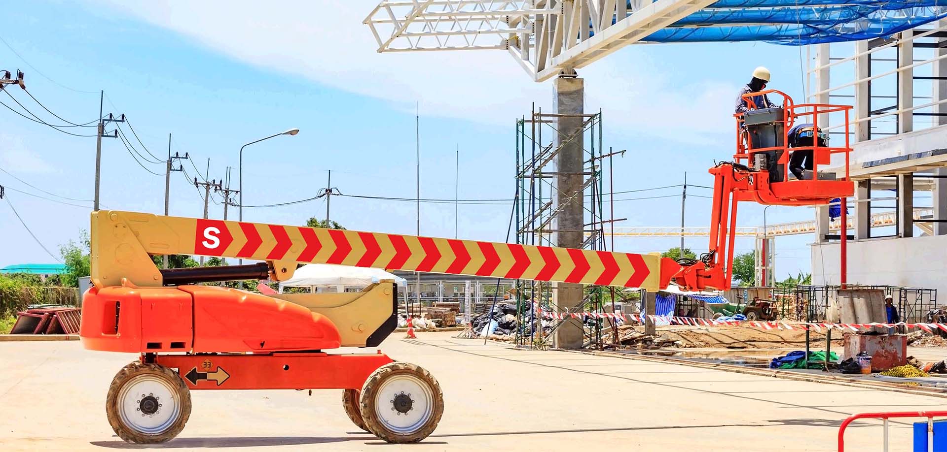 Opérateur sur une nacelle articulée pendant un chantier de construction.