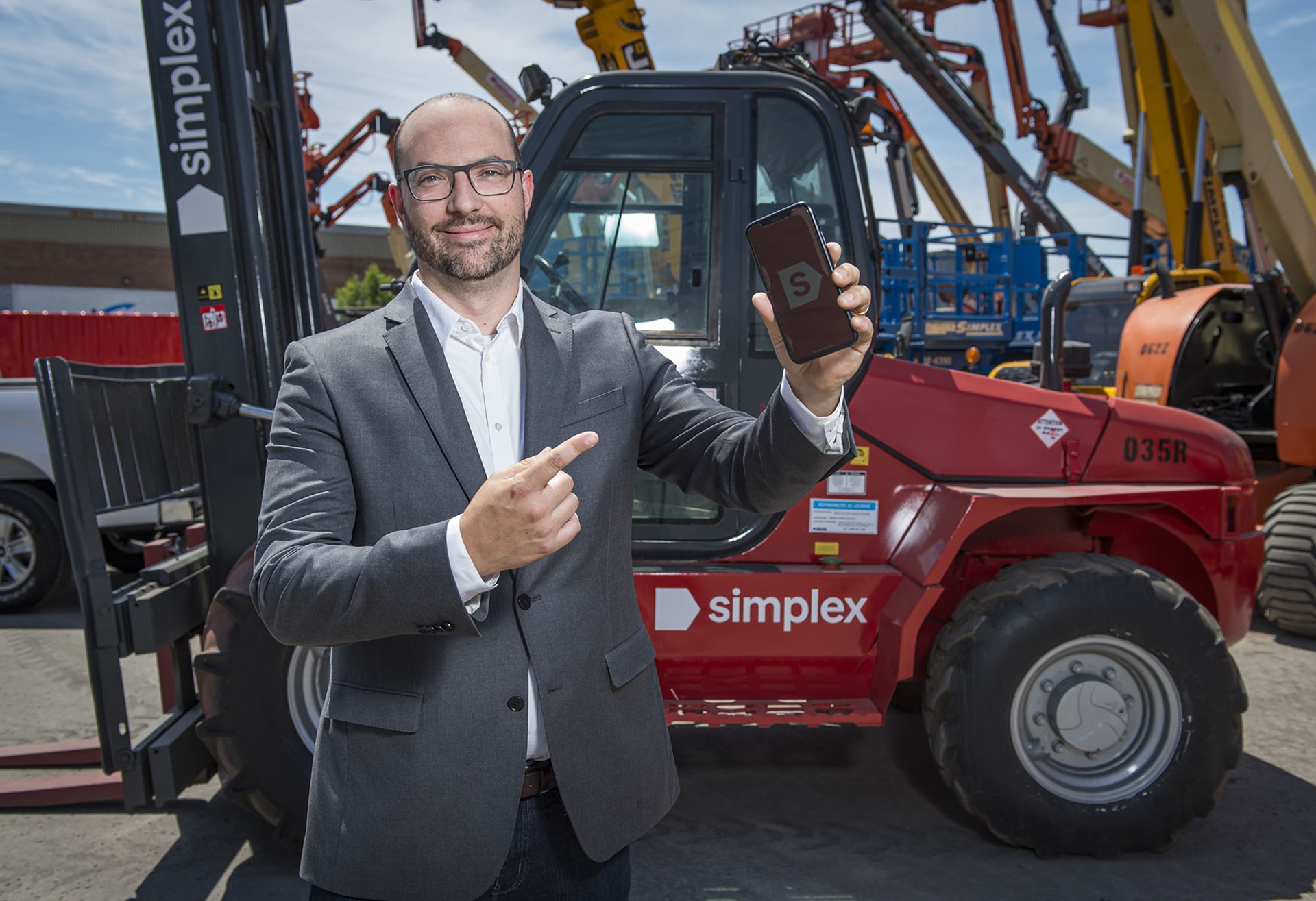 Euclide Véronneau, CEO de Simplex Location d'outils, tenant un téléphone portable dans une succursale.